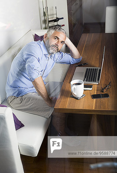 Portrait of businessman with laptop at his home office