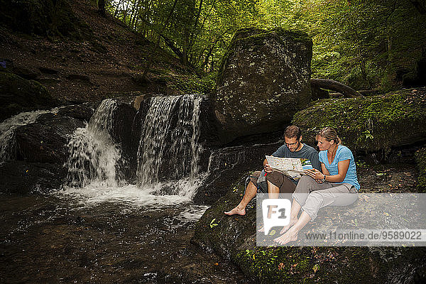 Germany  Rhineland-Palatinate  Moselsteig  Ehrbachklamm  couple reading map at waterfall