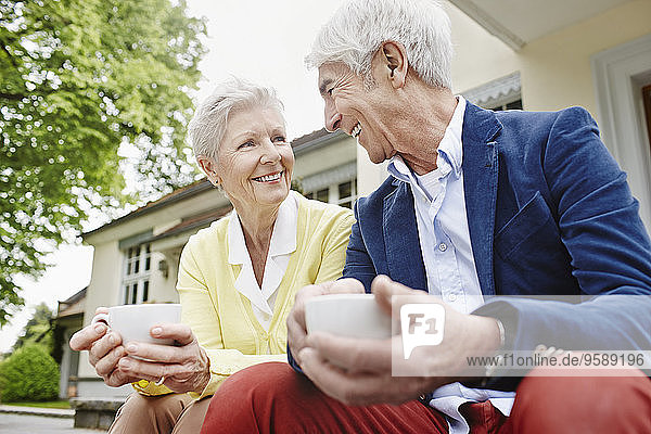 Deutschland  Hessen  Frankfurt  Seniorenpaar auf Stufen sitzend  Tee trinkend