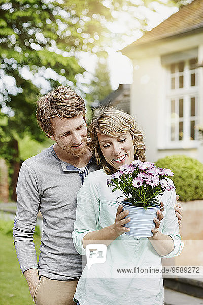 Deutschland  Hessen  Frankfurt  Glückliches Paar im Garten mit Blumentopf