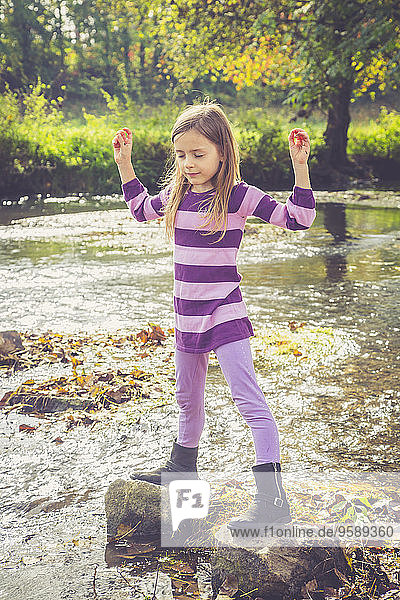 Little girl doing relaxation exercise at a brook