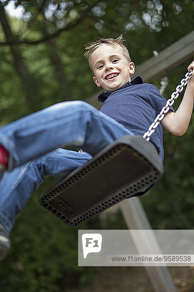 Portrait of smiling boy sitting on a swing