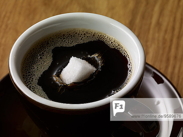 Zuckerwürfel in Tasse Kaffee