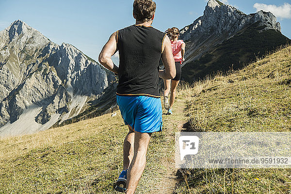 Österreich  Tirol  Tannheimer Tal  junges Paar beim Joggen in den Bergen