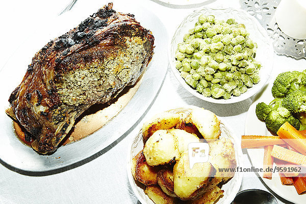 Abendessen mit gebratenem Fleisch  Kartoffeln  Karotten  Brokkoli und Saubohnen auf dem Tisch