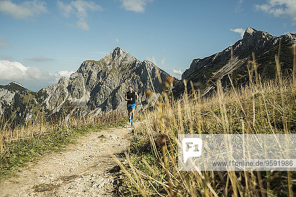 Austria  Tyrol  Tannheim Valley  young man jogging in mountains