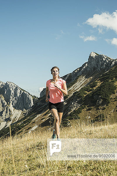 Österreich  Tirol  Tannheimer Tal  junge Frau beim Joggen im Gebirge
