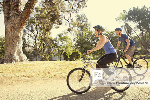 Mature couple cycling in park