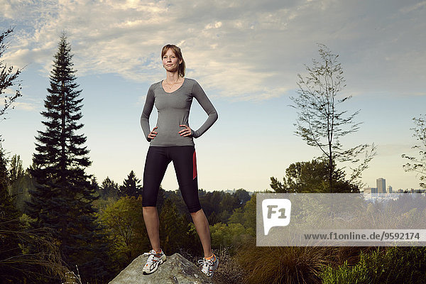 Portrait der Läuferin auf dem Felsblock im Park