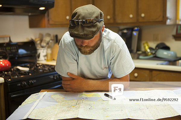 Mann studiert Karte der USA am Küchentisch
