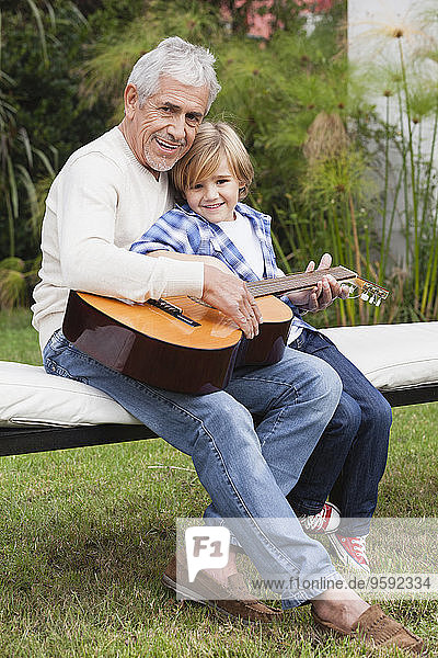 Großvater und Enkel mit Gitarre im Freien