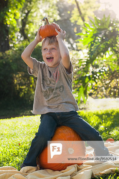 Boy sitting on pumpkin
