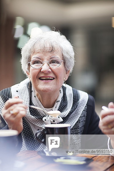Portrait of senior woman relaxing in a pavement cafe