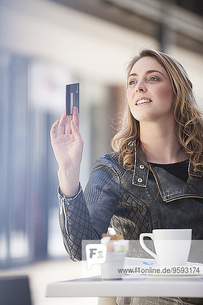 Junge Frau in einem Café mit Kreditkarte bezahlen