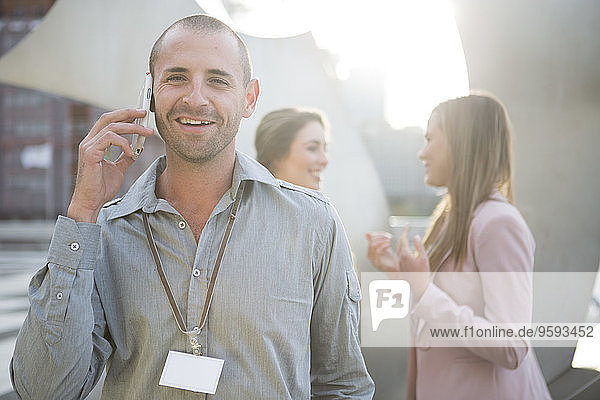Portrait of smiling businessman telephoning with smartphone