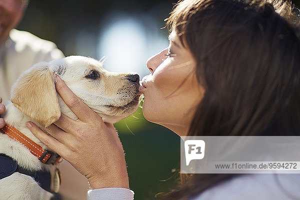 Frau küsst Hund Welpe