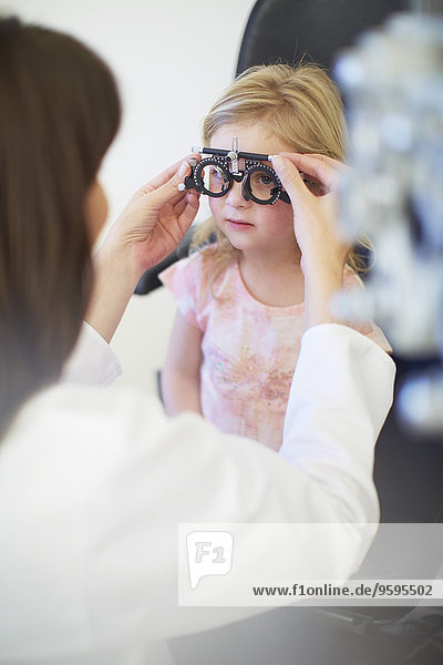 Eye doctor examining girl's vision
