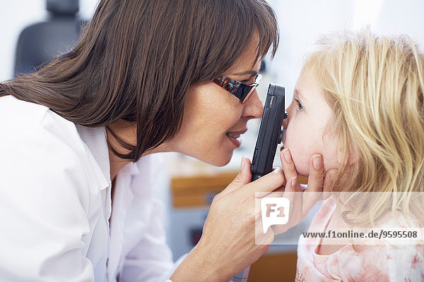 Augenarzt untersucht die Sehkraft des Mädchens