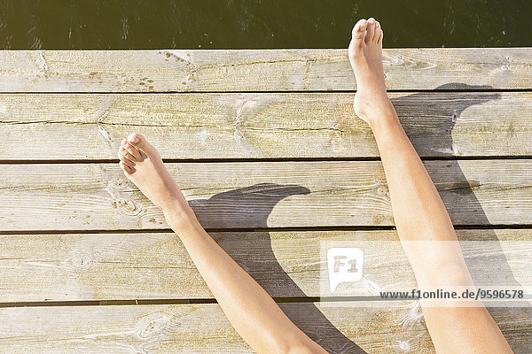 Niedriger Teil der Frau beim Sonnenbaden an der Strandpromenade