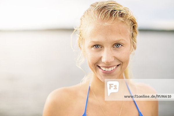 Porträt einer lächelnden jungen Frau gegen den See