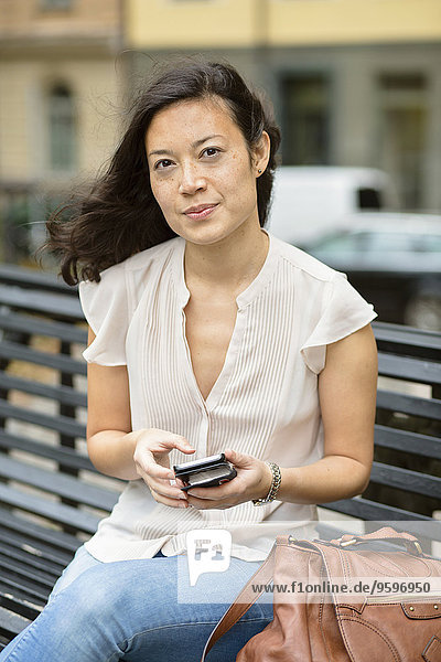 Porträt einer Frau mit Handy in der Stadt