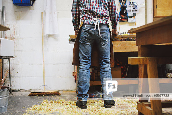 Ausschnitt eines reifen Handwerkers an der Werkbank in der Pfeifenorgel-Werkstatt