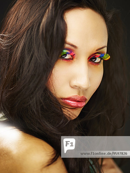 Junge Frau mit regenbogenfarbigen falschen Wimpern