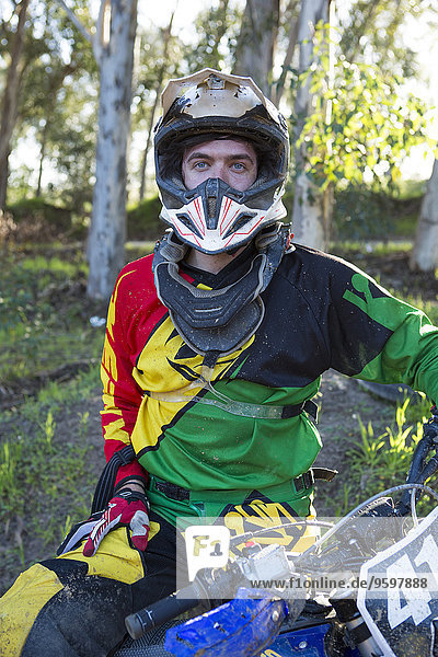 Portrait of young male motocross racer in forest