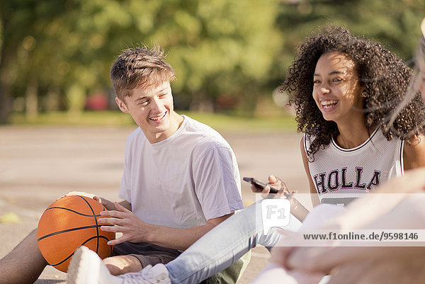 Gruppe junger erwachsener Basketballspieler beim Chatten