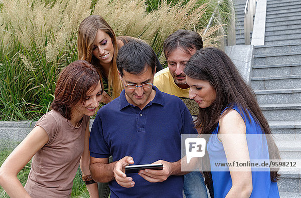 Gruppe von Freunden  die ein Smartphone anschauen