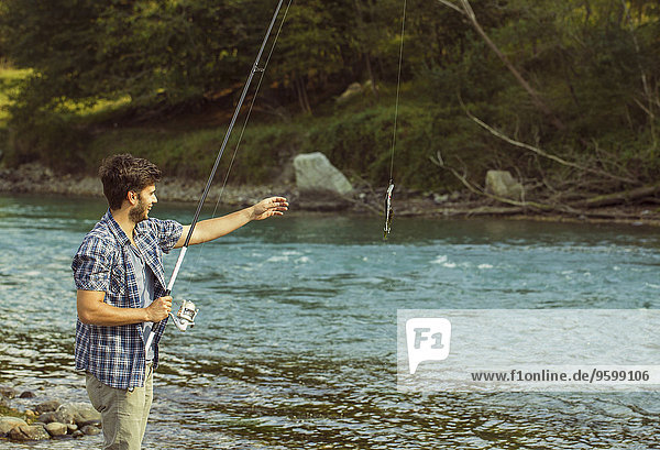 Junger Mann beim Fischfang im Fluss  Premosello  Verbania  Piemonte  Italien