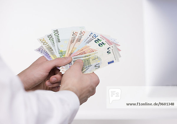 Gefächerte Euro Geldscheine in Männerhänden