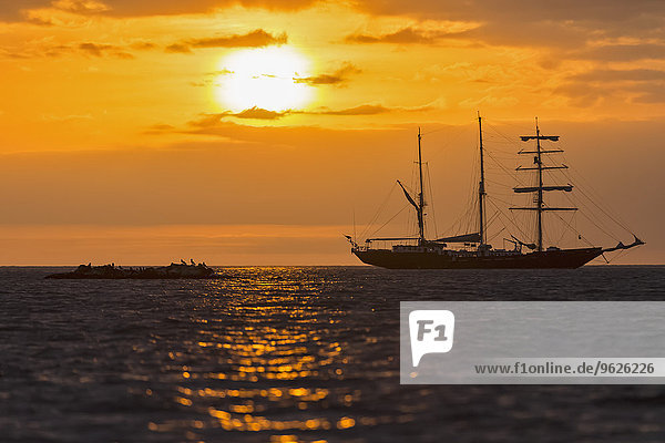 Pazifischer Ozean  Segelschiff auf den Galapagosinseln bei Sonnenuntergang