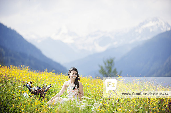 Young woman having picnic on alpine meadow