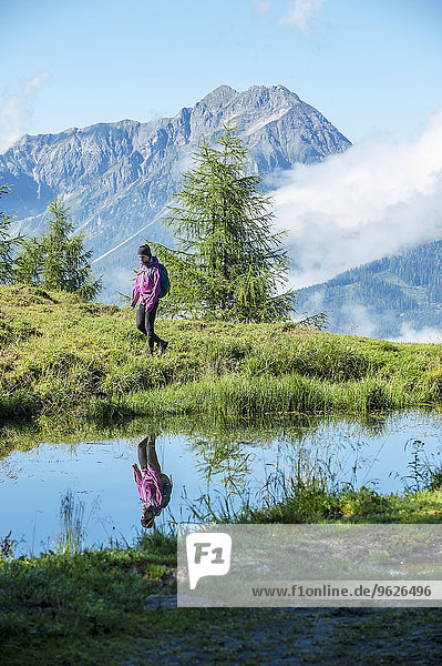Österreich  Altenmarkt-Zauchensee  junge Frau beim Wandern in alpiner Landschaft