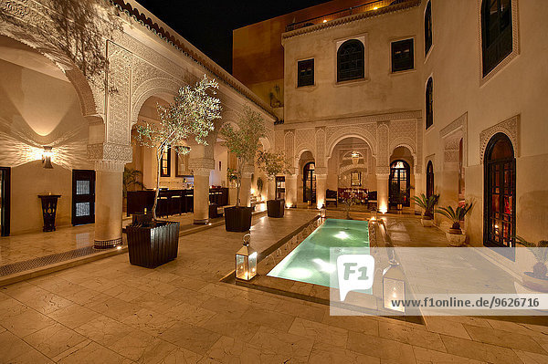 Marokko  Fes  Hotel Riad Fes  Innenhof mit beleuchtetem Pool bei Nacht