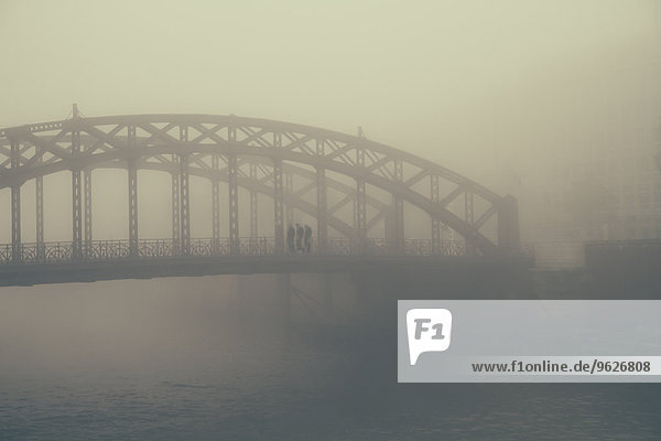 Deutschland,  Hamburg,  HafenCity,  Brücke mit Fußgängern im Nebel