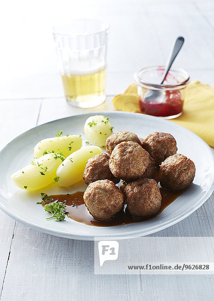 Koettbullar  schwedische Fleischbällchen mit Kartoffeln und Sauce auf dem Teller  Preiselbeeren