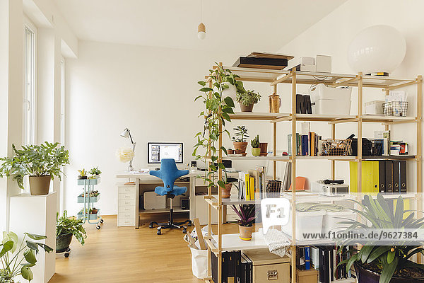Home Office mit Regal und Pflanzen im modernen Gebäude