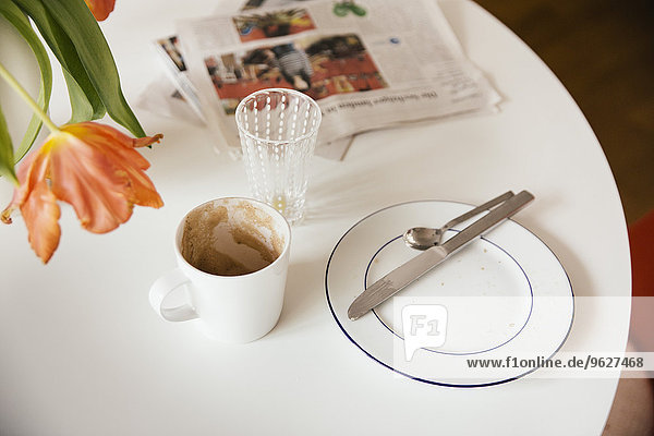 Frühstückstisch mit Zeitung nach Gebrauch