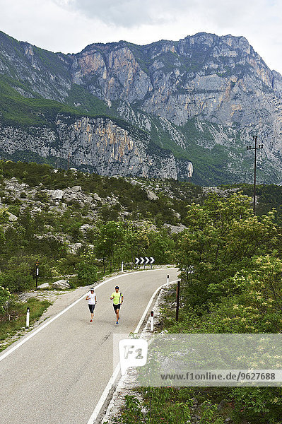 Italy  Trentino  couple running on road near Lake Garda