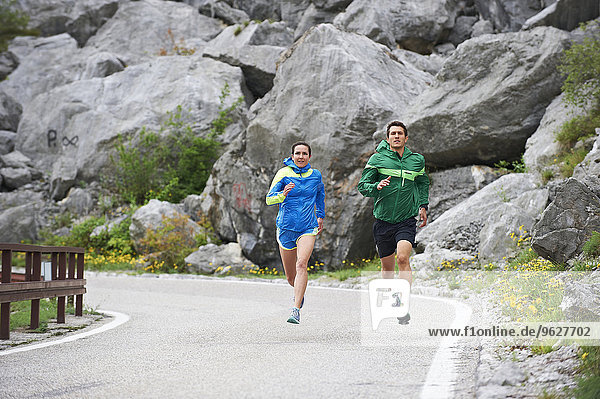 Italy  Trentino  couple running on road near Lake Garda