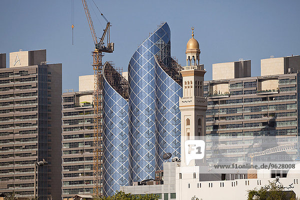 VAE  Dubai  Baustelle eines Wolkenkratzers neben Minarett