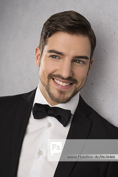Portrait of smiling man wearing dinner jacket and bow
