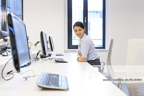 Portrait of smiling woman at desk in office