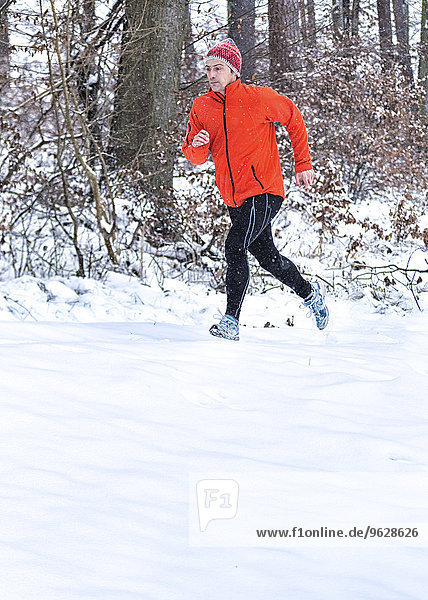 Deutschland  Baden-Württemberg  Holzberg  Mann joggen im Schnee