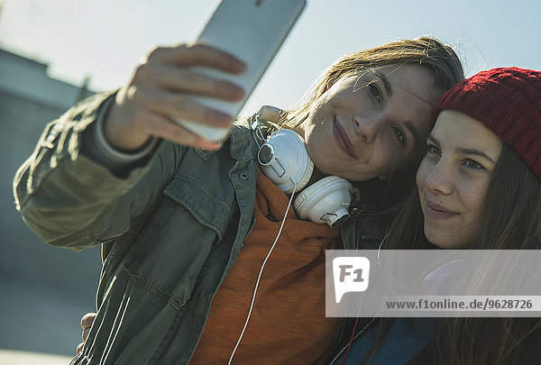Zwei Teenager-Mädchen im Freien  die Selfie nehmen.