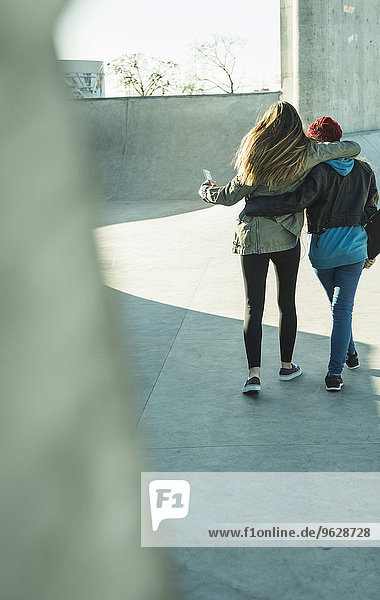 Zwei Teenager-Mädchen umarmen sich im Skatepark