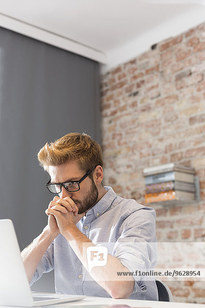 Young man at desk using laptop