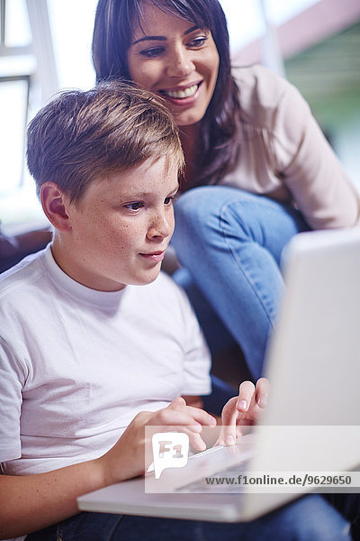 Mutter und Sohn zu Hause mit Laptop